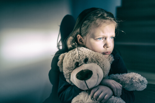 Niña abrazada a un osito de peluche
