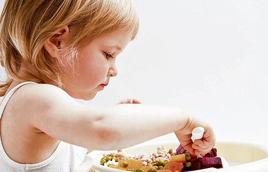 niña comiendo mientras sus padres usan la culpa para educar