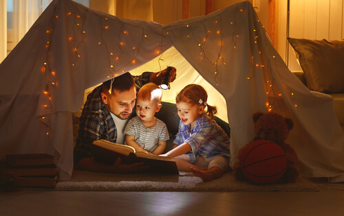 Padre leyendo con sus hijos