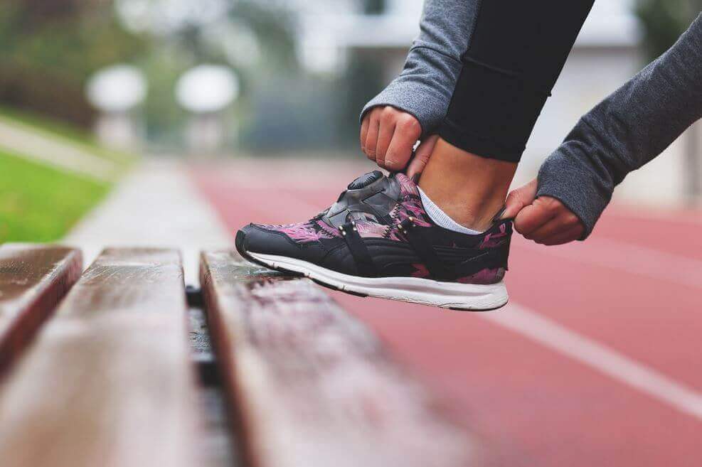 Persona poniéndose una zapatilla de deporte