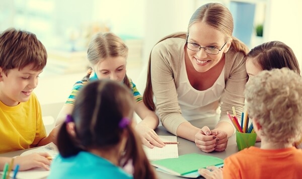 profesora con alumnos representando el trabajo cooperativo