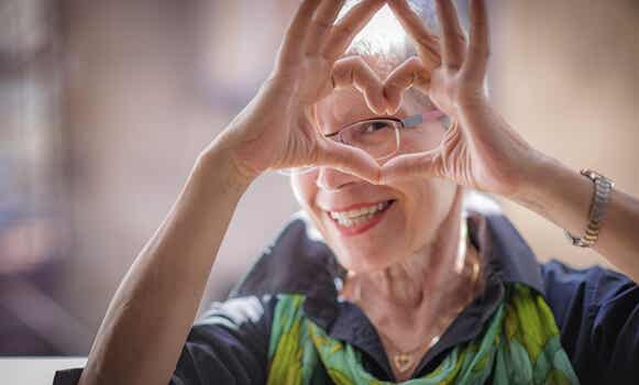 mujer mayor feliz haciendo corazón con las manos satisfecha por envejecer saludablemente