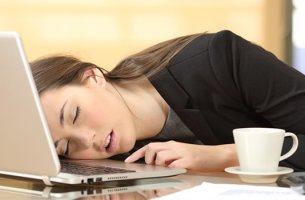 Chica dormida sobre el ordenador con narcolepsia