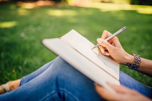 mujer escribiendo sobre sus ejercicios de yoga en casa