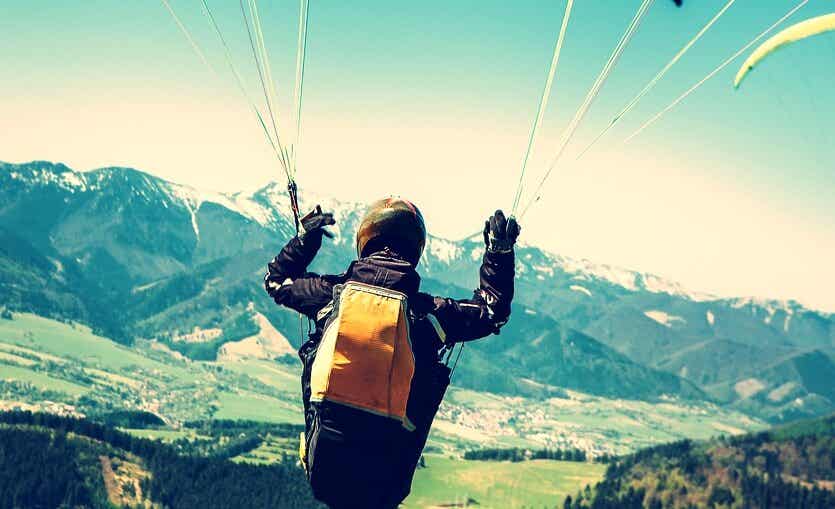 chico con paracaídas representando la atracción por las conductas de riesgo