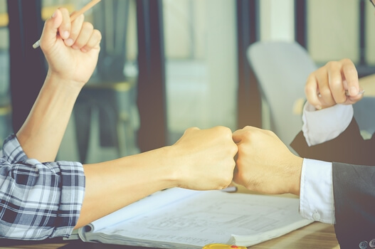 amigos chocando puños representando la comunicación kinestésica