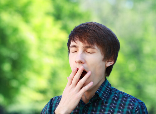 Hombre bostezando en la calle