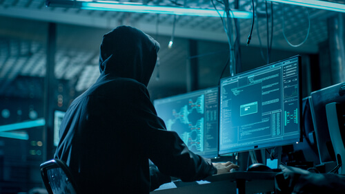 Hombre con un ordenador haciendo doxing