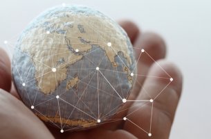 Mano con bola del mundo para representar los países más resilientes