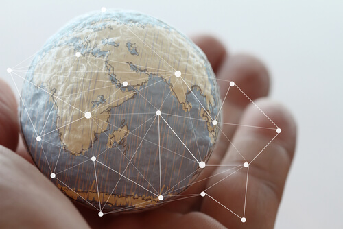 Mano con bola del mundo para representar los países más resilientes