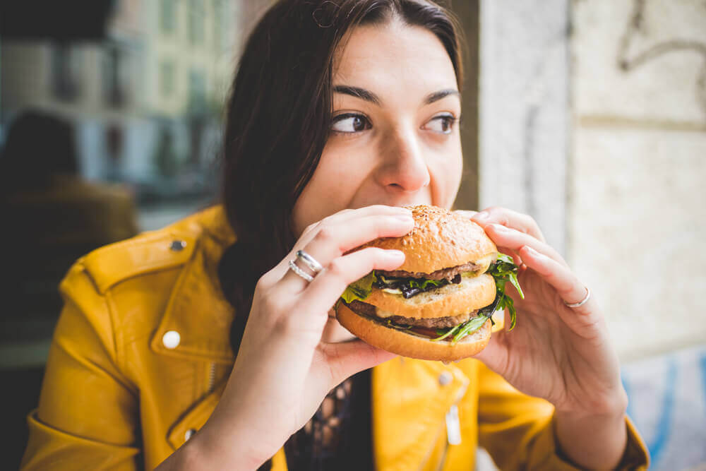 Mujer comiendo una hamburguesa
