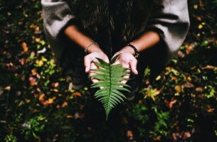 mujer con hoja en las manos intentando buscar el sentido de la vida