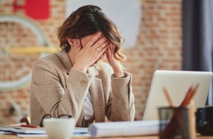 Mujer en el trabajo con estrés por su relación con los compañeros trepa