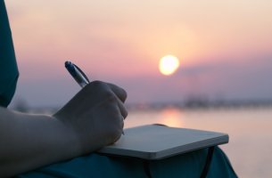 mujer escribiendo al amanecer intentando crear un crear un diario emocional