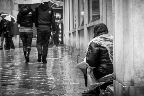 Mujer pidiendo en la calle para representar el efecto espectador