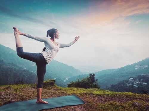 Mujer practicando una nueva postura de yoga con su cuerpo