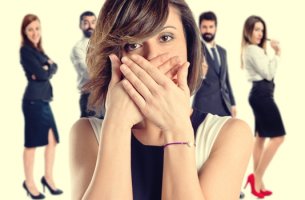 mujer que se tapa la boca porque tiene miedo a hablar en público