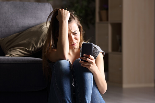 Mujer triste con el móvil