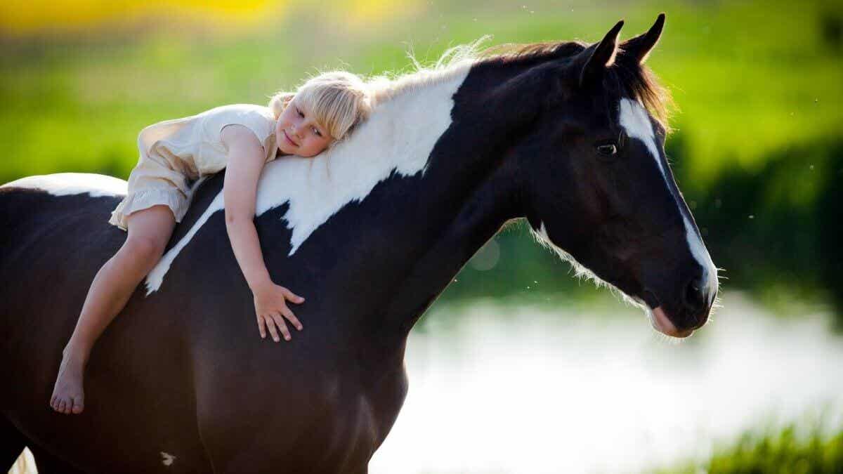 Niña abrazada a caballo