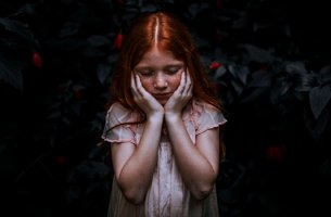 niña pelirroja que se coge el rostro representando las frases para las personas altamente sensibles (PAS)