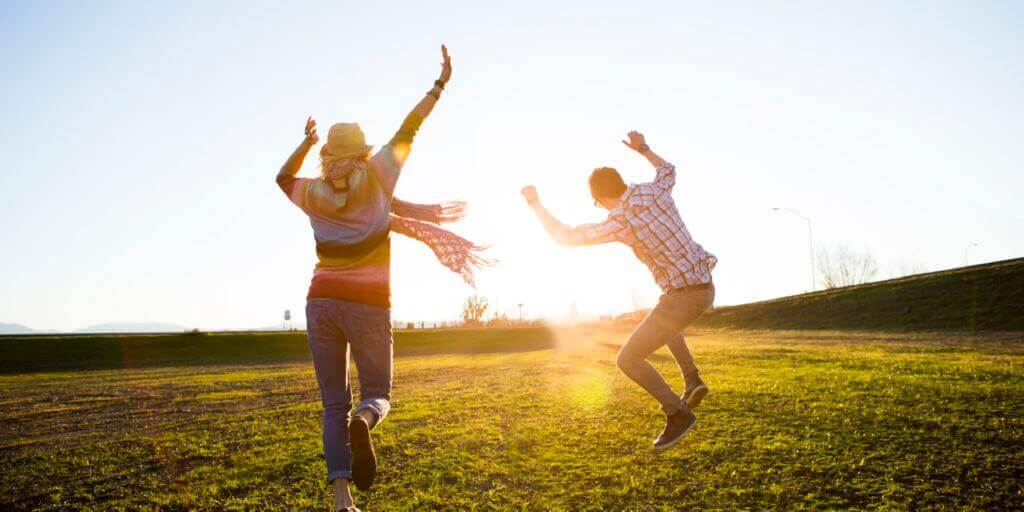 Pareja saltando en el campo