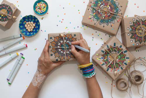 A girl drawing mandalas on gift packages.