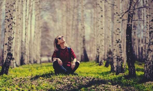 chica sentada en el bosque simbolizando a los solteros felices