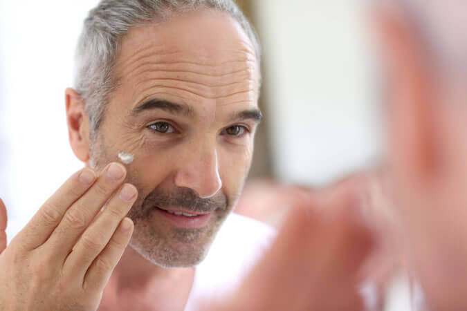 Hombre de 50 echándose crema