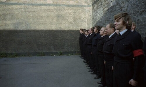 Hombre de pie de espaldas a la pared