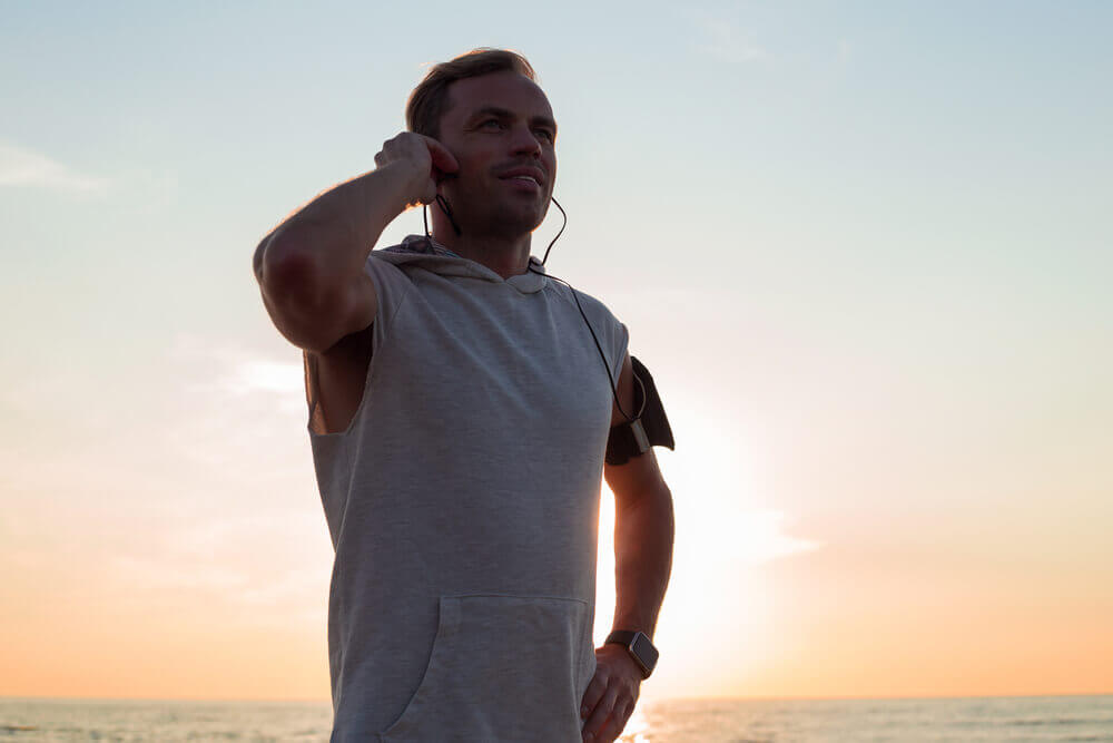 Man listening to music while exercising representing emotional intelligence in sports.