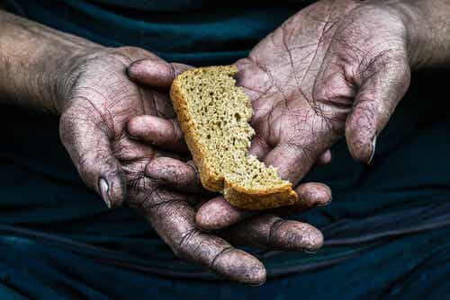 Mano con un trozo de pan de una persona pobre