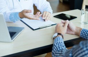 Médico con paciente leyendo el consentimiento informado