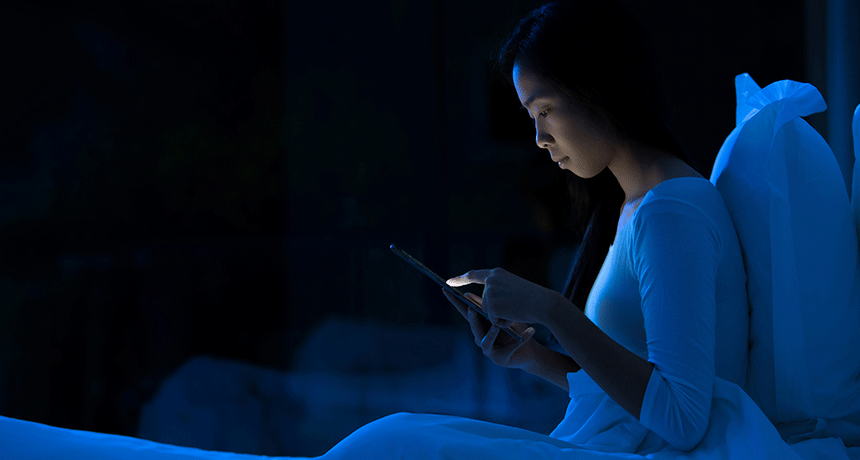 mujer viendo el móvil por la noche representando el síndrome de la vibración fantasma