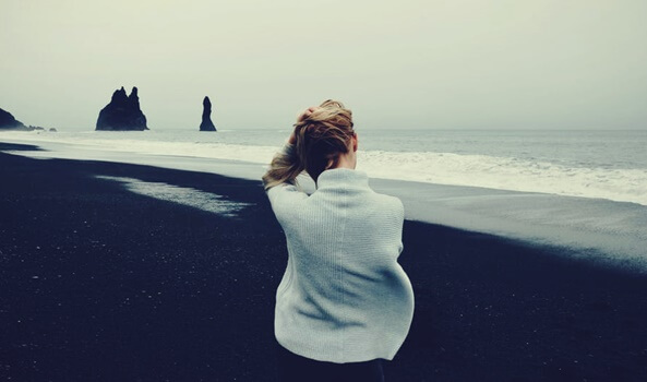 chica en la playa pensando en la tolerancia a la incertidumbre