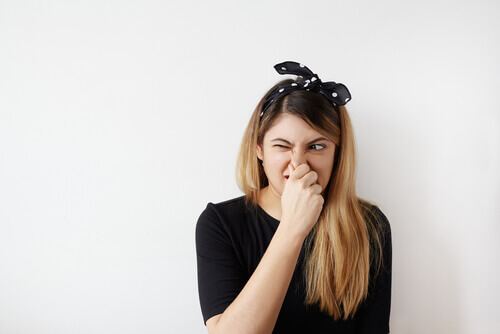 Mujer tapándose la nariz