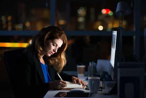 Mujer trabajando por la noche en la oficina para representar al workaholic