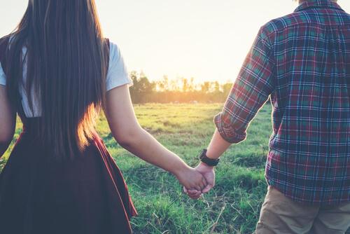 Pareja caminando agarrada de la mano