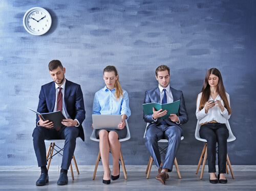 Personas sentadas esperando para hacer una entrevista de trabajo