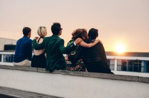Amigos sentados viendo el atardecer