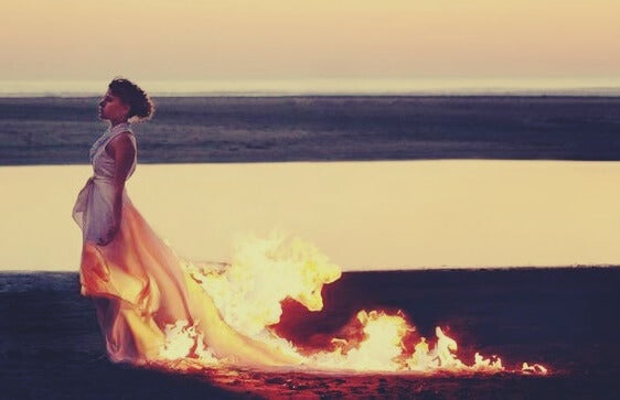 mujer con vestido en llamas simbolizando una persona autodestructiva