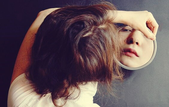 chica mirándose a espejo aceptando que el el otro sea feliz