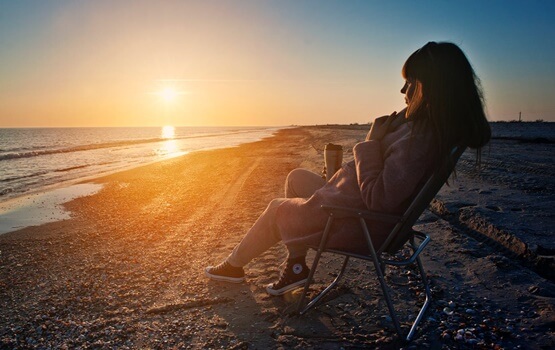 chica en la playa pensando en poner distancia
