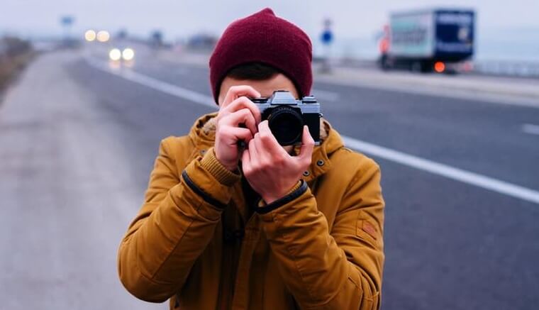 hombre haciendo fotos simbolizando cómo ser feliz, según la ciencia