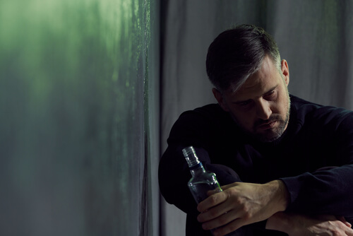 Hombre con botella de alcohol en la mano