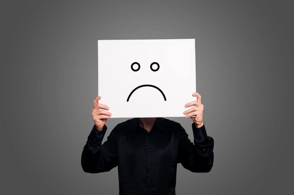 Hombre con cartel con cara negativa