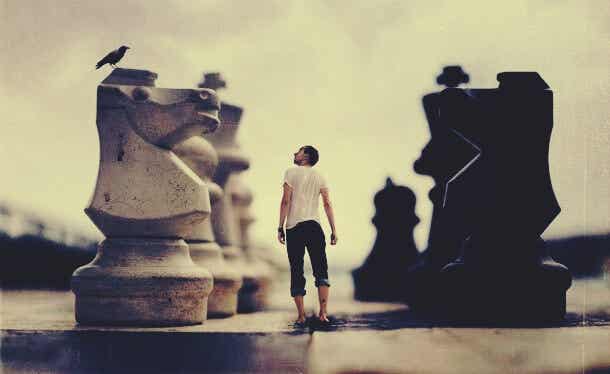 hombre entre piezas de ajedrez simbolizando el miedo está dominando tu vida