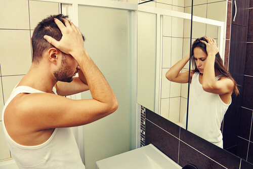Hombre viéndose en el espejo como una mujer
