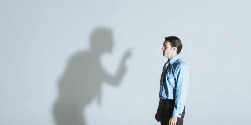 Hombre mirando a su sombra mientras le critica