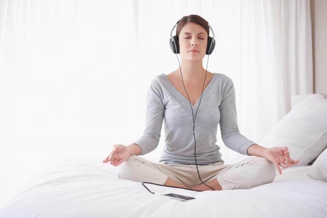 chica con auriculares practicando técnicas de relajación para dormir mejor