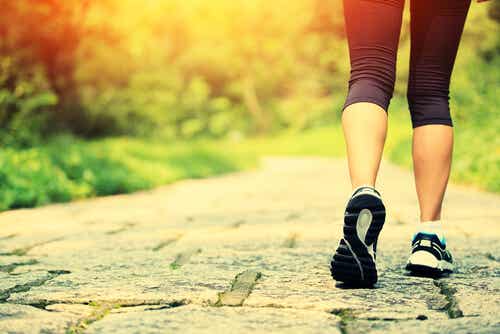 Mujer con zapatillas de deporte caminando simbolizando cómo ser feliz, según la ciencia